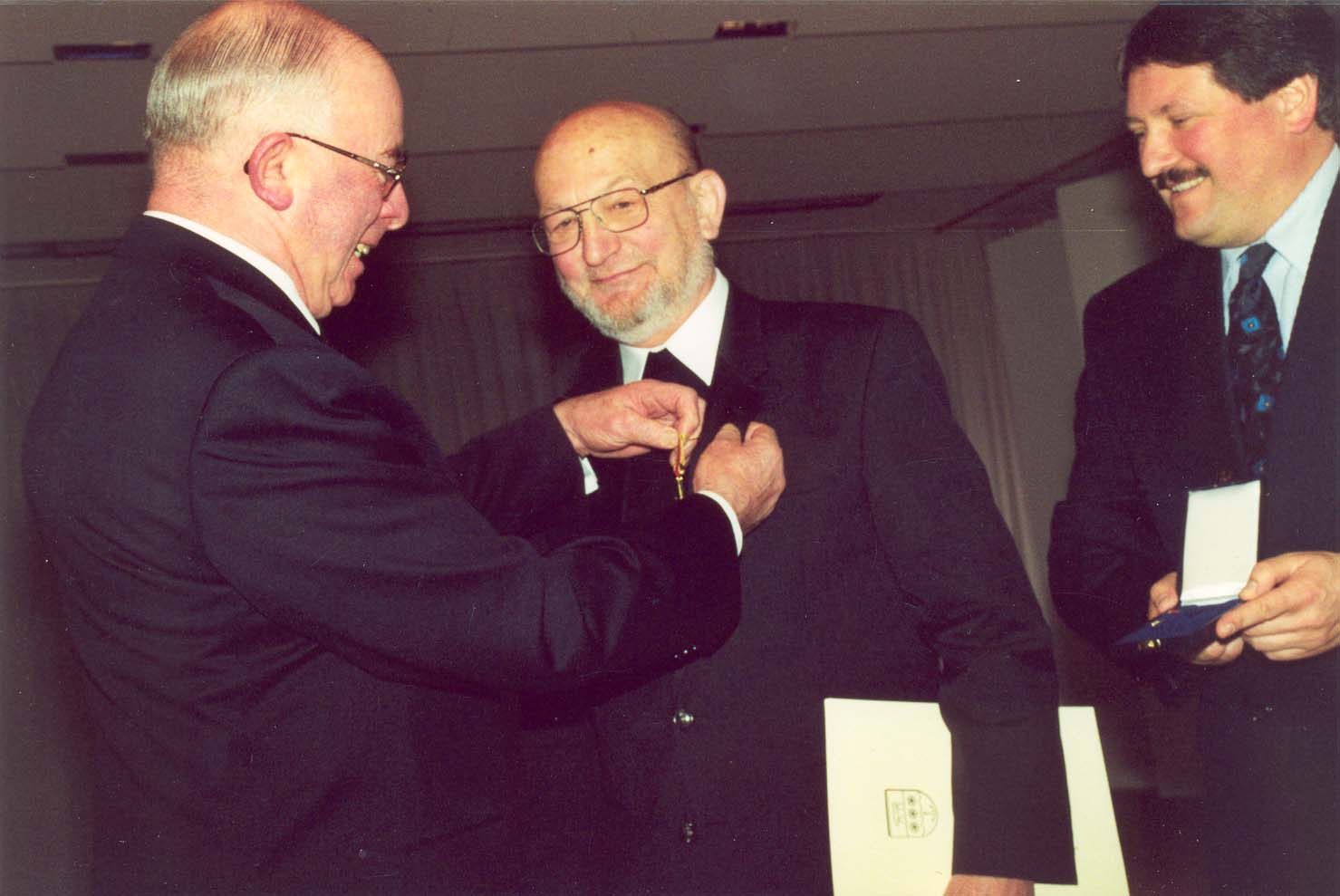Landrat Meiners überreicht Pater Meyer-Schene 1999 das Bundesverdienstkreuz; rechts: Erster Kreisrat Winter Landrat Meiners überreicht Pater Meyer-Schene 1999 das Bundesverdienstkreuz; rechts: Erster Kreisrat Winter